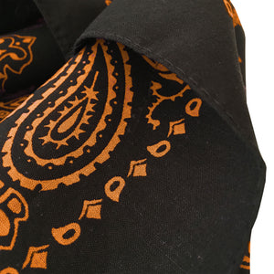 Black bandana with orange print hemmed edge closeup